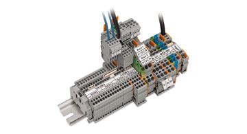 Eine Reihenklemme mit mehreren angeschlossenen Kabeln, montiert auf einer Hutschiene, mit farbigen Markierungen.